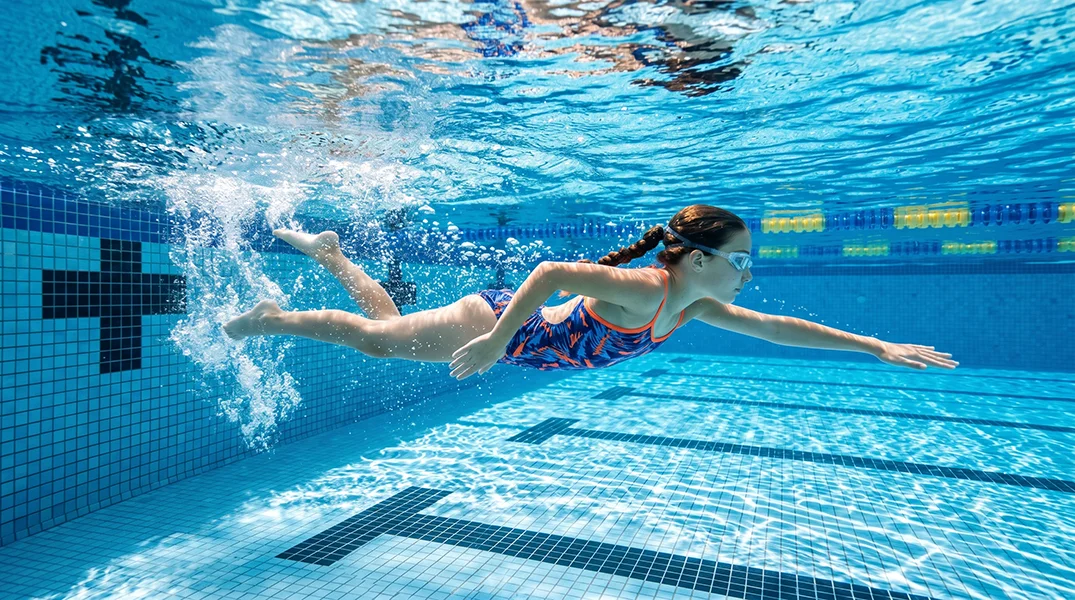 Swimmer gliding through crystal clear pool water